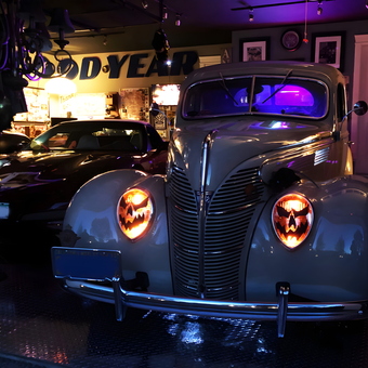 Classic Cars and Goodyear Sign in Neon Lit Garage - Gerry
