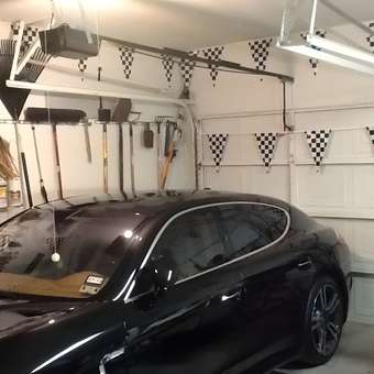 Organized garage with wall tool rack and black car - Little red from Irving, TX