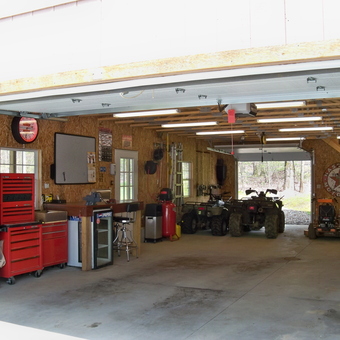 Organized garage with tool cabinets and ATVs - manskos