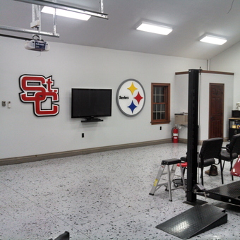 Organized garage with car lift, cabinets, and wall decor - Charlie from St, Clairsville, OH