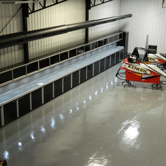 Sleek Garage with Custom Cabinets and Race Car Frames - Car Guy Garage Custom Cabinets