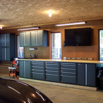 Modern garage with cabinets, workbench, and TV - Papa Mike from Chester, SD