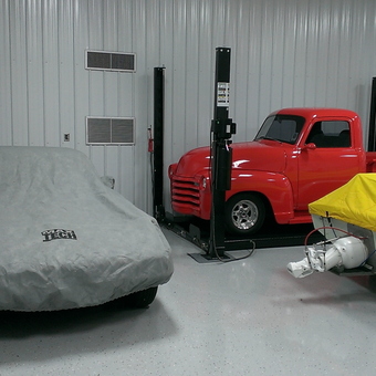 Classic Truck on Car Lift with Covered Cars and Boat - Anonymous
