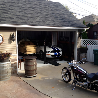 Organized garage with car lift, barrels, and motorcycle - Trouble from Grosse pointe park, MI