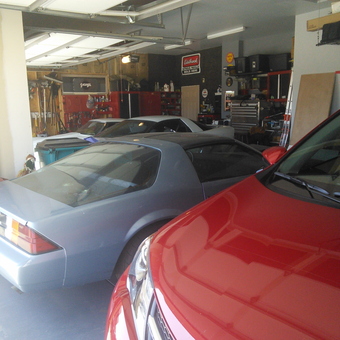 Organized garage with classic cars, tool storage, and cabinets - ski