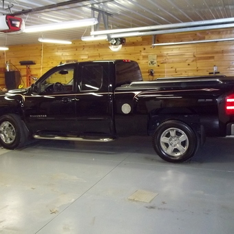 Organized wood-paneled garage with black Silverado truck - Gunner from Ottumwa, IA