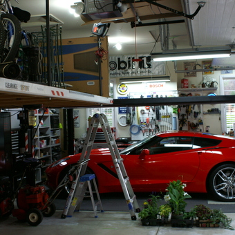 Organized garage with car lift and red sports car - jerry carguy from pinckney, MI