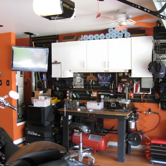 Organized garage workspace with tools, cabinets, and TV - Mark from Tomball, TX