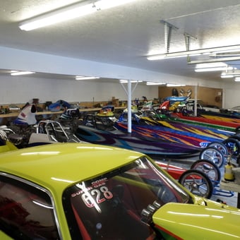 Colorful Dragsters and Classic Cars in Well-Lit Garage - Need for speed