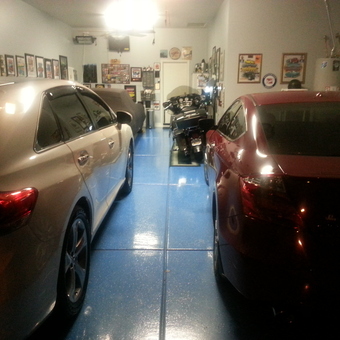 Organized garage with cars, motorcycle, and wall decor - baebra from Goodyear, AZ