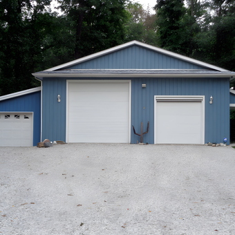 Large Blue Three-Door Garage with Gravel Driveway - Blacktruck from Adrian, MI