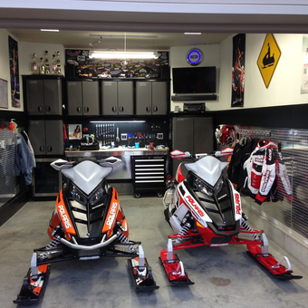 Organized garage with snowmobiles, cabinets, and tool storage - Clark from Jesup, IA