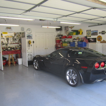 Organized garage with Corvette, tool bench, and wall signs - Mike from Le Claire, IA