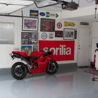 Organized garage with motorcycle, wall art, and cabinets - Larry from Layton, UT