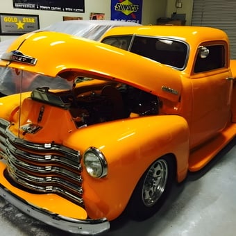 Classic orange Chevy truck in garage with wall signs - Carlos from Salinas, CA