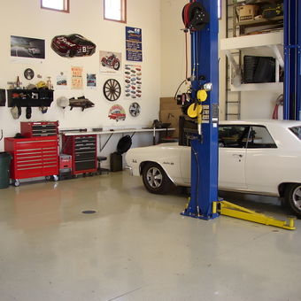 Organized garage with car lift, toolboxes, and wall decor - brian from cottage grove, WI