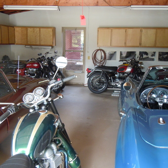 Classic Cars and Motorcycles in Organized Garage - Anonymous