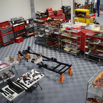 Organized garage with tool chests, car frame, and storage racks - Steve