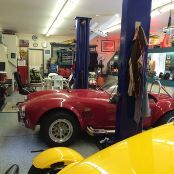 Organized garage with car lift, classic cars, and wall decor - USA 2 from troy, mi