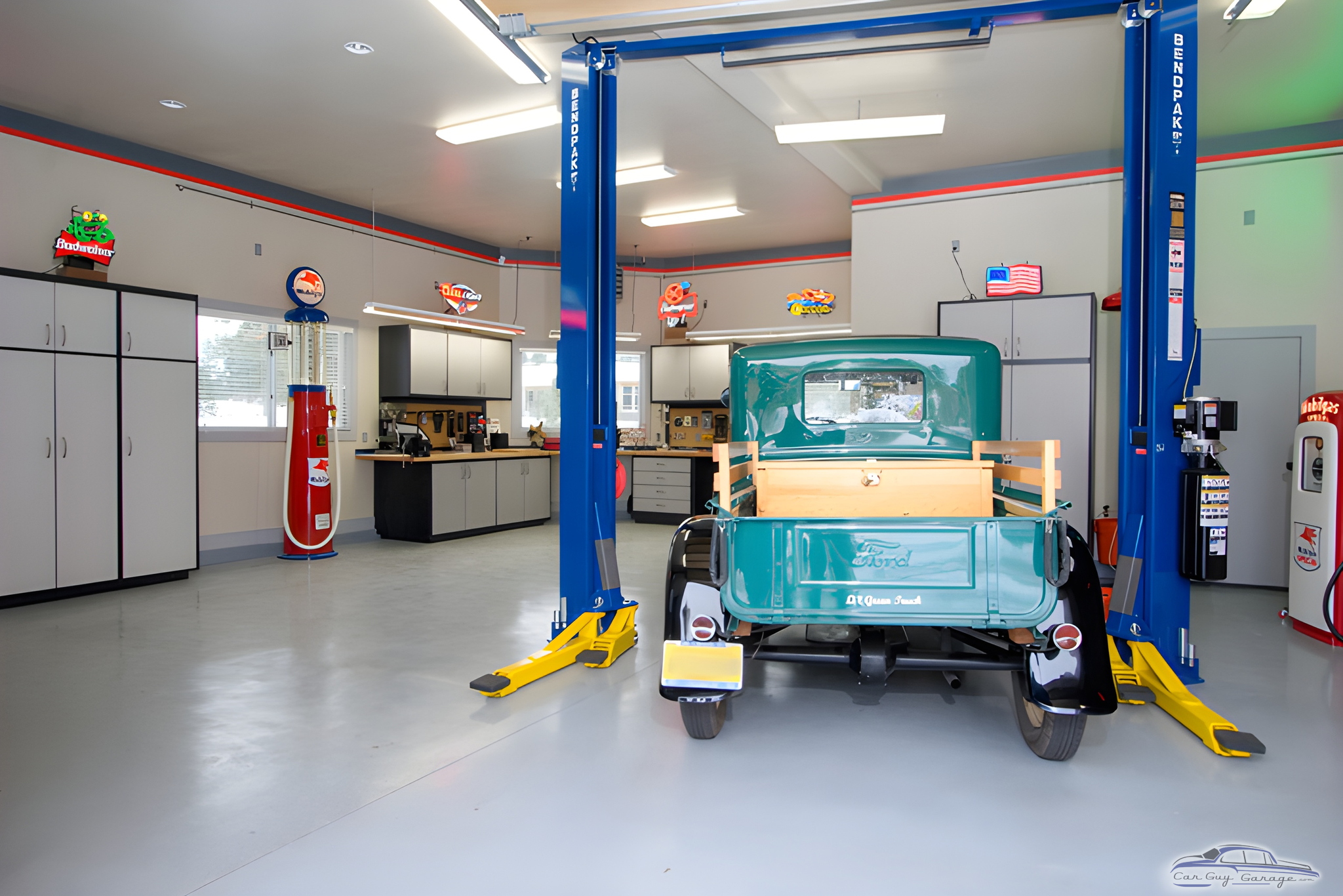 Organized garage with car lift, cabinets, and vintage signs - Ian from Denver, CO