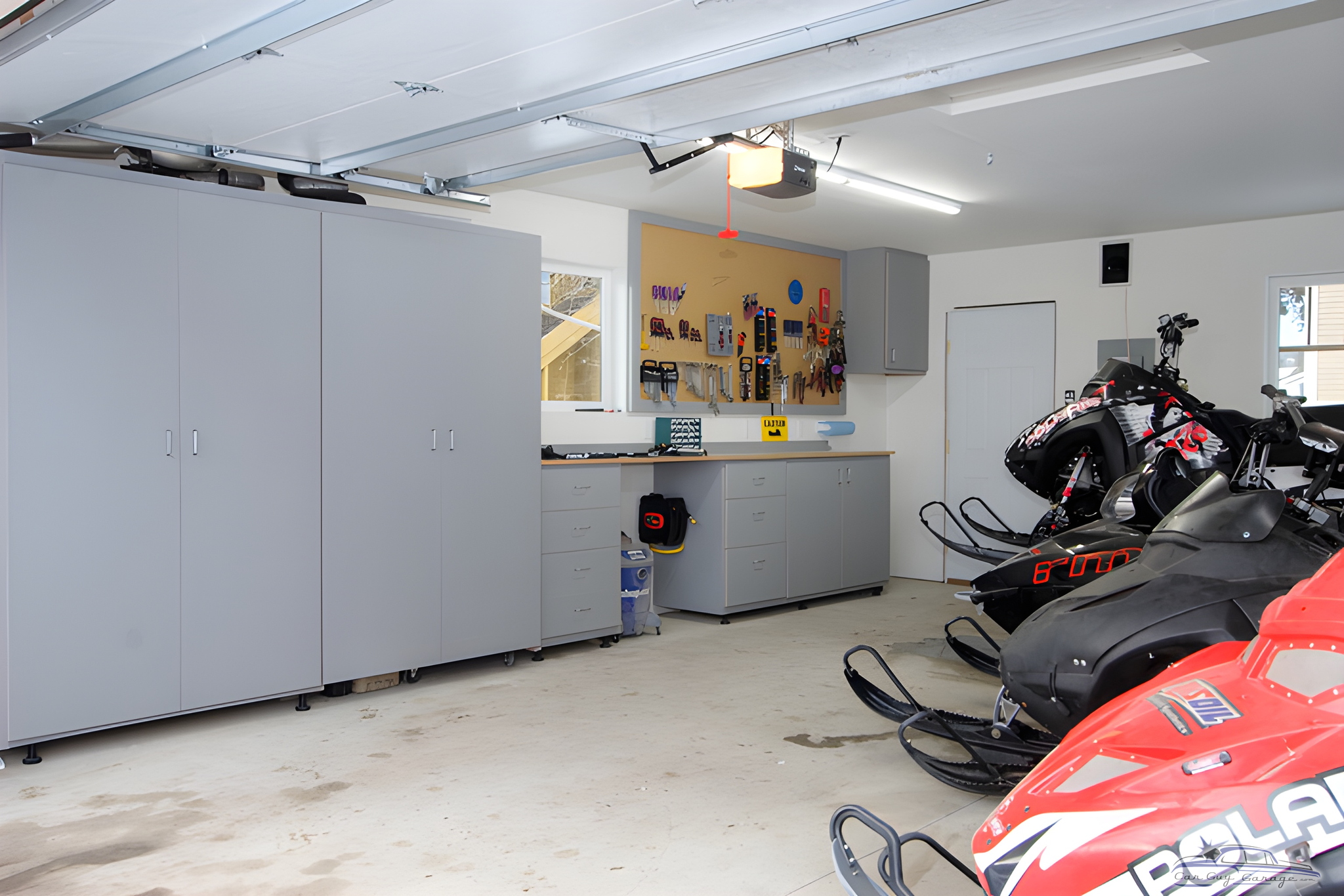 Organized garage with cabinets, workbench, and snowmobiles - Ian from Denver, CO