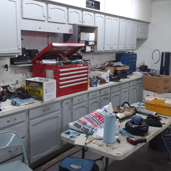 Organized Garage with Tool Cabinets, Toolboxes, and Rims - Anonymous
