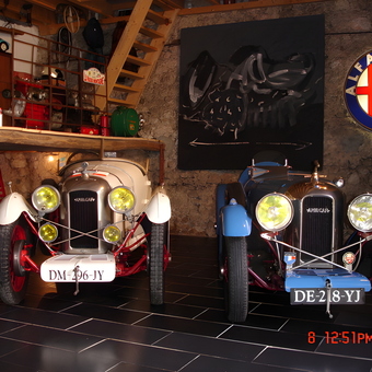 Vintage Cars in Rustic Garage with Alfa Romeo Sign - Anonymous